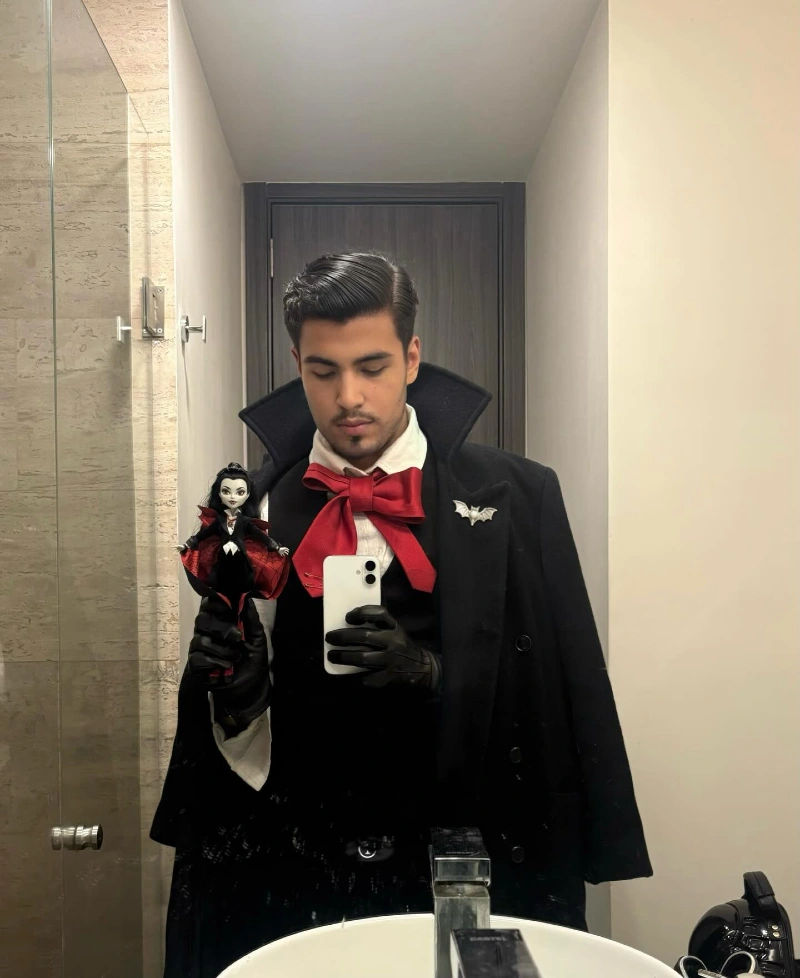 Black Wool Overcoat with Crimson Ribbon Tie and Bat Lapel Pin