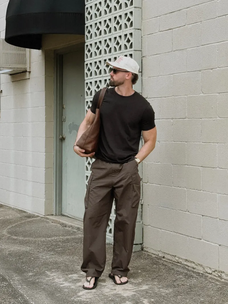 Fitted Black Tee with Loose Brown Cargo Pants and Leather Bag