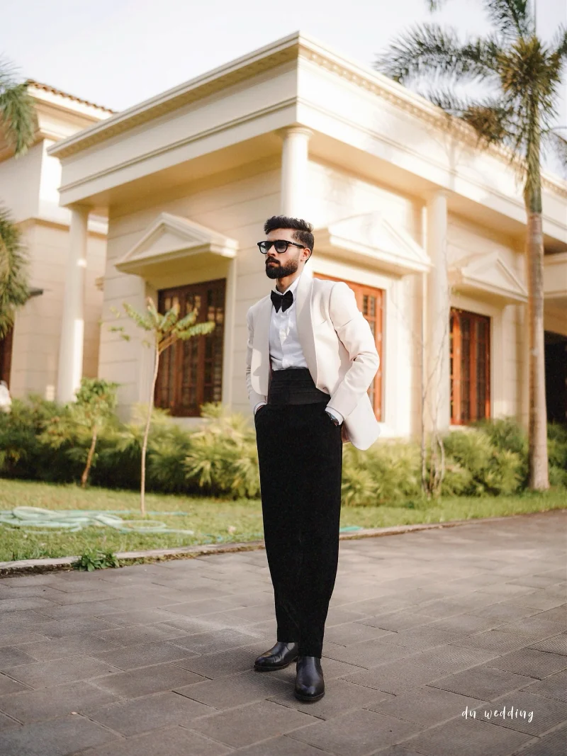 Ivory Tuxedo Jacket with Black Cummerbund and Leather Boots