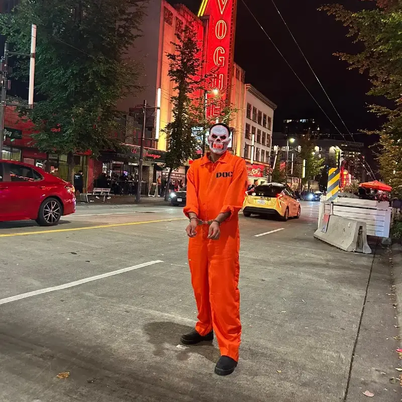 Orange Prison Jumpsuit with Handcuffs and Skull Mask.webp